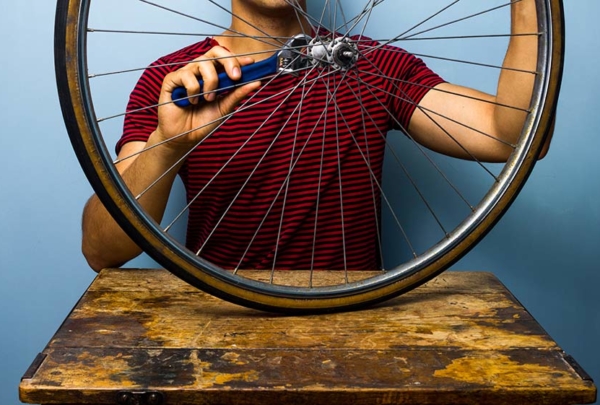 Man fixing bicycle wheel.
