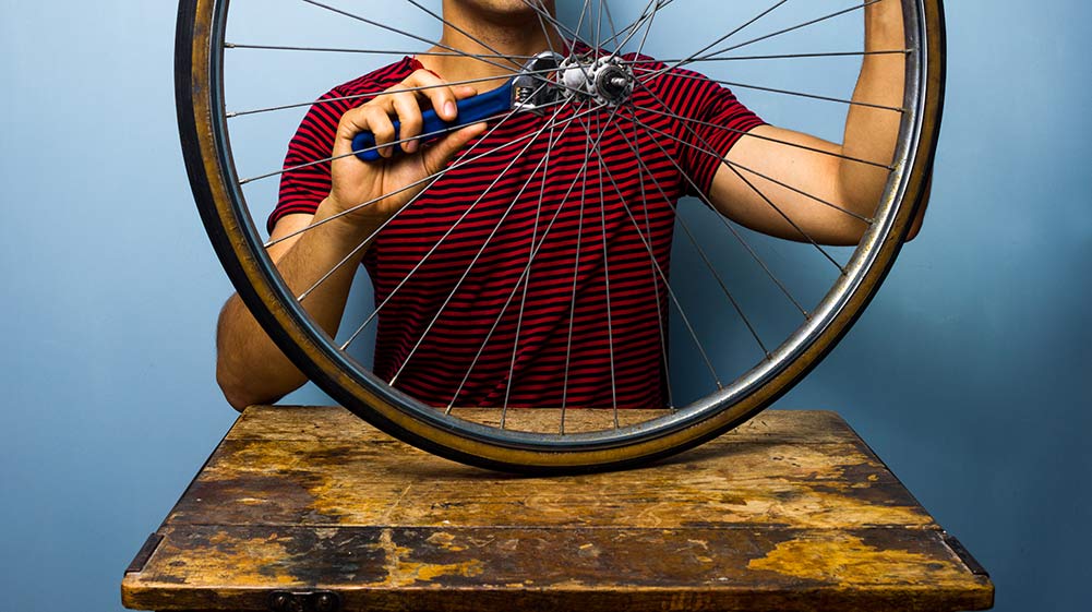 Man fixing bicycle wheel.