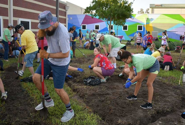 Haskell team members landscaping the front of a middle school.