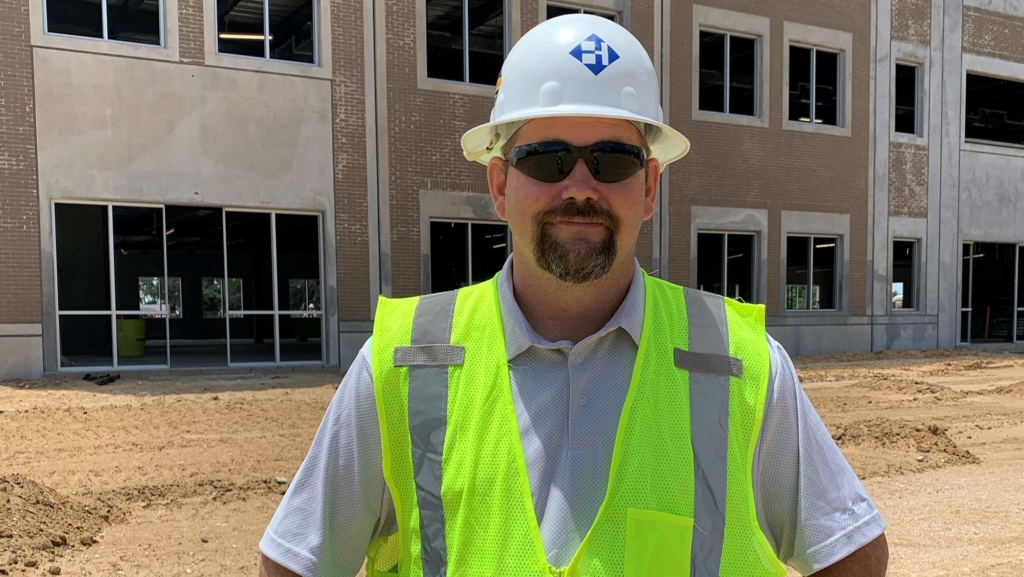 Haskell's Superintendent Sonny Carter posing on a job site wearing a hard hat and safety vest.
