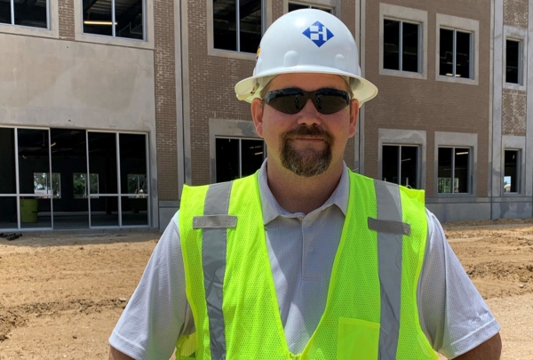 Haskell's Superintendent Sonny Carter posing on a job site wearing a hard hat and safety vest.