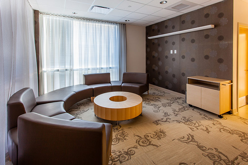 Photo of seating at the California Proton Cancer Therapy Center. Round brown leather couch around doughnut shaped table.