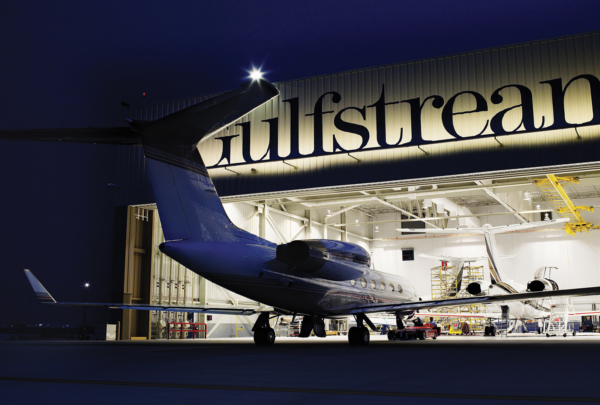 Exterior of Gulf Stream Service Center at night. Plane entering hangar.