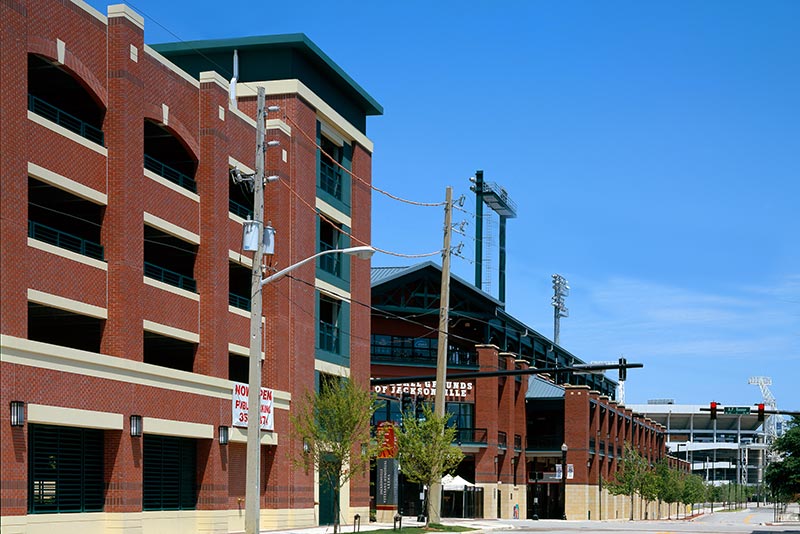 Exterior photo of Jacksonville Municipal Garages. Photo is a street view of the arena and sports parking garage. Red brick with green trim and accents.