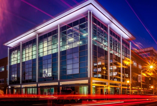 Exterior photo of Maryland Proton Treatment Center at night. Vehicle taillights create red streaks in time lapse image.