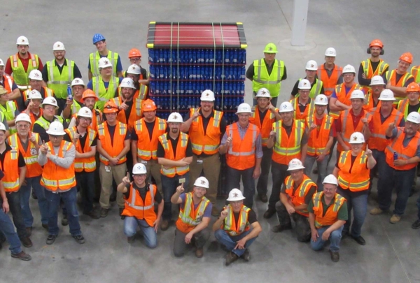 Haskell employees posing with a pallet of beer.
