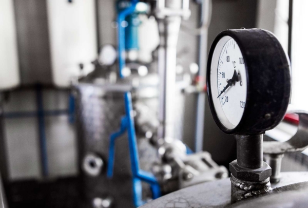 Distillery equipment. Temperature gauge sits atop metal vessel.