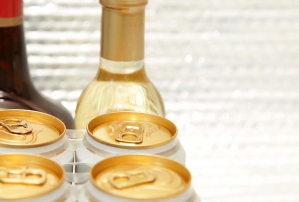 Aluminum cans sitting next to glass bottles.