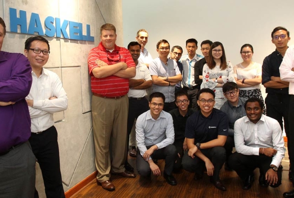 Haskell employees posing with Haskell signage.