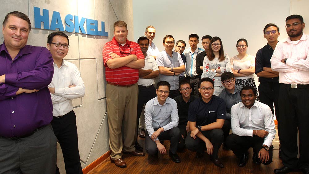 Haskell employees posing with Haskell signage.