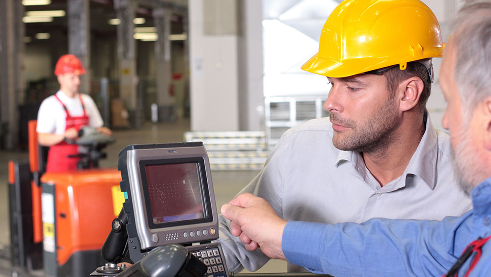 Construction workers looking at technology on a job site.