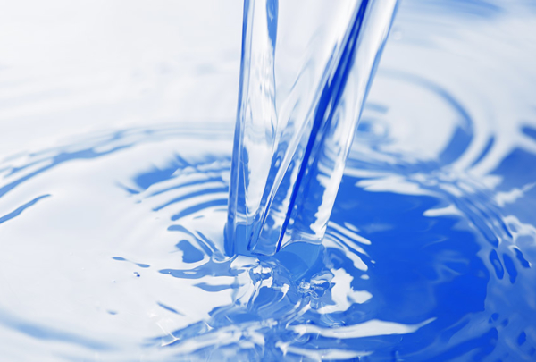 Clear water pouring into blue container