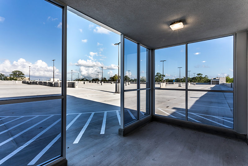 Photo through the glass windows/doors exiting out to the top floor of the parking structure.