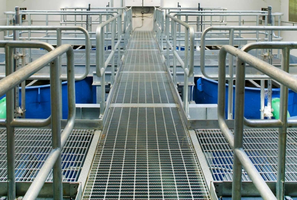 Aluminum grating walkways above six large blue tanks at the Indian Head Wastewater Treatment Plant.