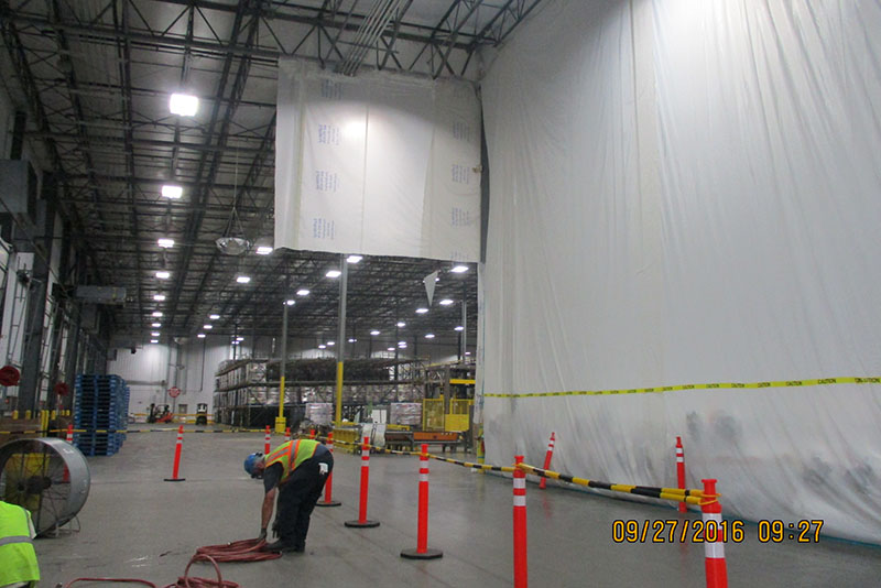 Needing to isolate packaged product from ongoing repairs in the 40-foot-tall warehouse, Haskell devised an unorthodox solution: Hang temporary plastic walls from ceiling to floor lined along the bottom with water-absorbing sandbags. The barriers worked as intended, protecting the product and allowing work to continue.