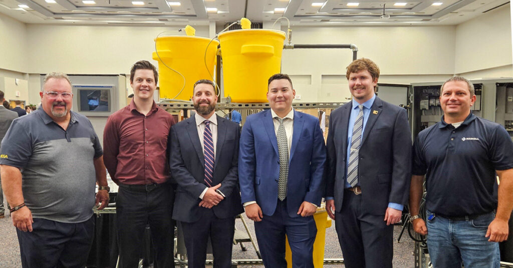 UNF Process Skid team members pose in front of their senior design project. From left are Greg Kline of Vega Americas; Daniel Fowler, Electrical; Adrian Hoover, Mechanical, Bryce Lovelace, Mechanical; Lake Miller, Electrical; and Haskell’s Christian Beckman.