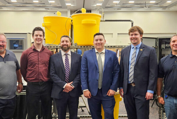 UNF Process Skid team members pose in front of their senior design project. From left are Greg Kline of Vega Americas; Daniel Fowler, Electrical; Adrian Hoover, Mechanical, Bryce Lovelace, Mechanical; Lake Miller, Electrical; and Haskell’s Christian Beckman.