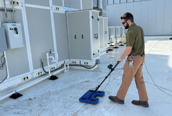 Quality Coordinator Grant Foreman operates the IntegriScan Electronic Leak Detection system on the roof of Miller Electric Center, the Jacksonville Jaguars practice facility and sports performance center.