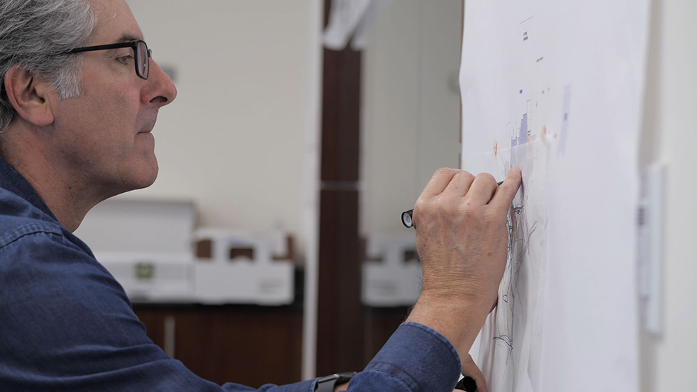 Haskell's Chris Flagg drawing on a sheet of paper.|