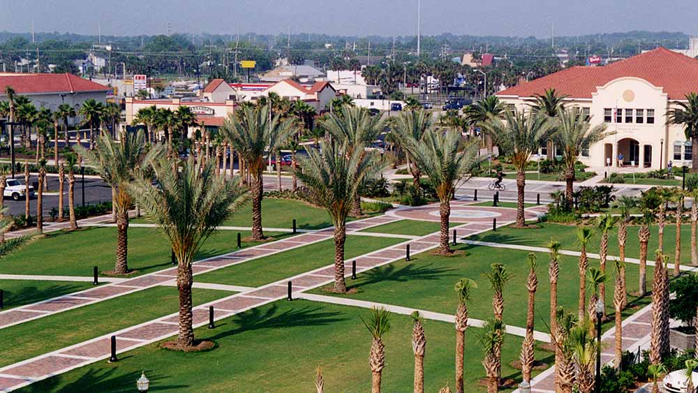 Palm trees line brick sidewalks that lead throughout the location.|