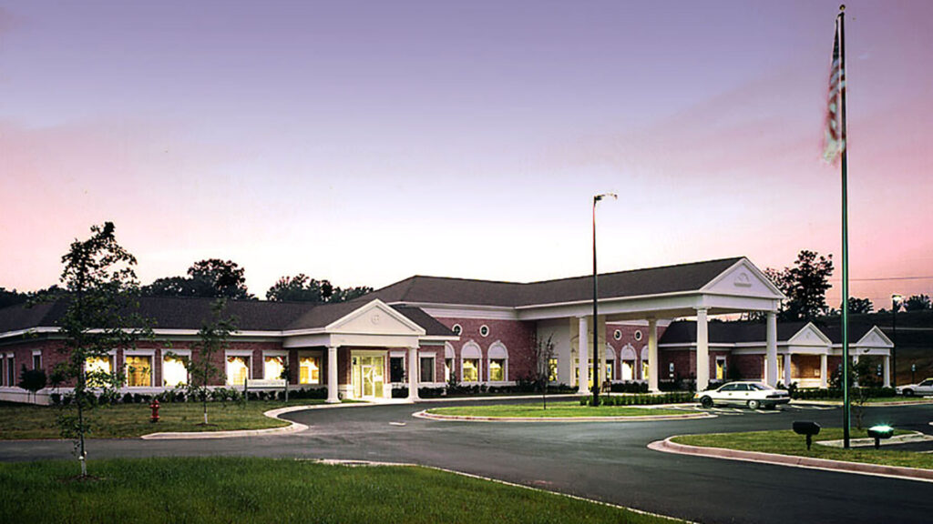 Exterior photo of Healthpark Hospital entrance at dusk.|