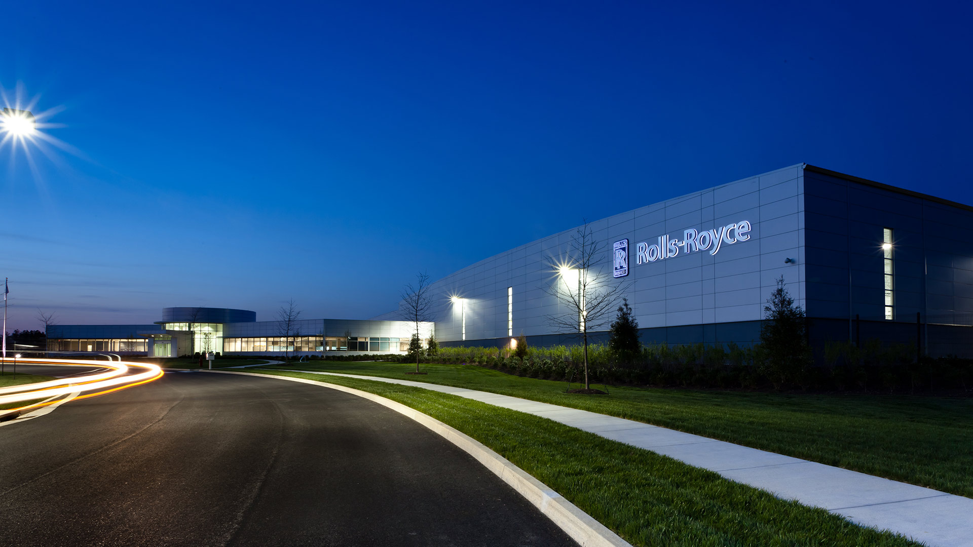 Exterior of Rolls Royce Crosspointe Rotatives Facility in the evening with street lamps on.