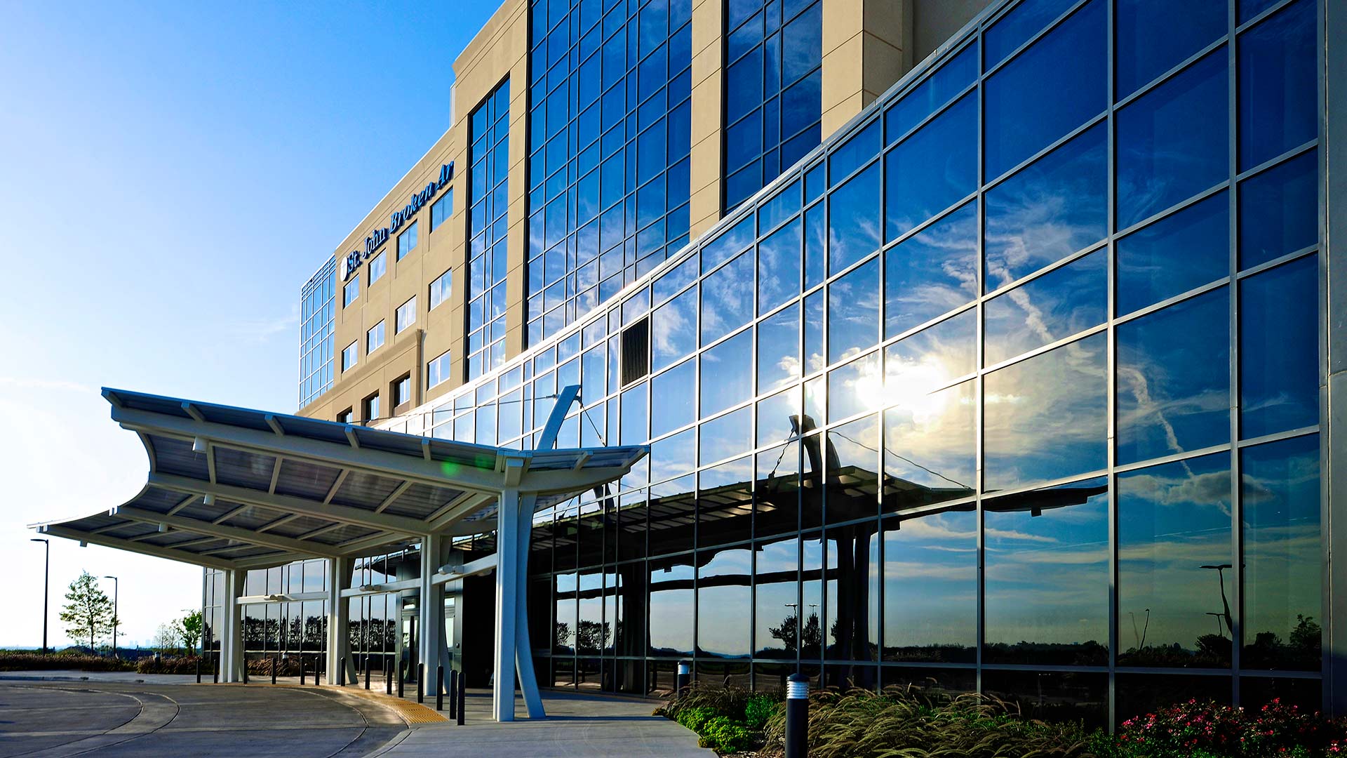 Exterior photo of St. Johns Broken Arrow Medical Campus. Sun reflecting off the six-story glass building.