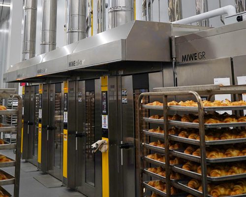 Stainless steel ovens and portable racks filled with baked rolls