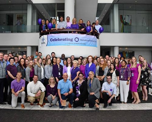 Large group of people wearing purple gather for photo after Haskell Women's Network event