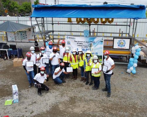 Philippines office employees wearing hard hats show off safety awards