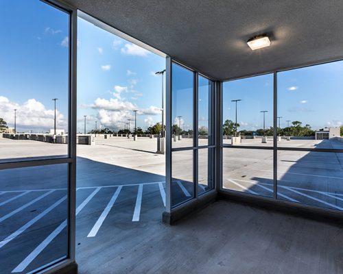 Photo through the glass windows/doors exiting out to the top floor of the parking structure.