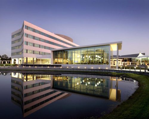 Exterior photo of Cafeteria and Office Building reflecting in retention pond