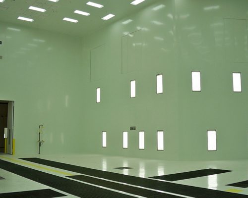 Interior of Gulfstream Paint Hangar. Large empty room with white walls and fluorescent lighting.