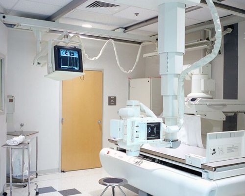 Interior photo of imaging room at Healthpark Hospital. X-ray table and monitoring equipment.