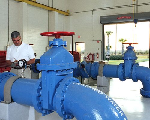 Interior photo from inside the facility. Large blue pipes and valves.