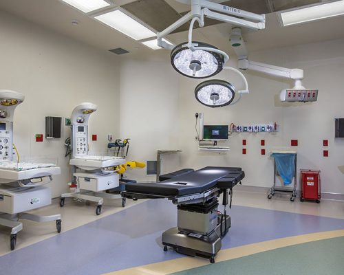 Photo of cesarean section room at Jupiter Medical Center. Delivery bed, big lights, and newborn warming stations.