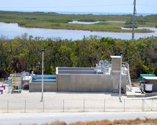 Looking down at the Layton wastewater treatment system. Purple and blue pipes extend out of the ground and system.