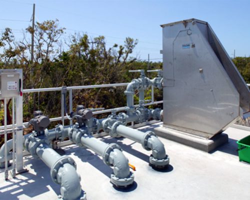 Pipes, controls, and metal structure on top of concrete water container