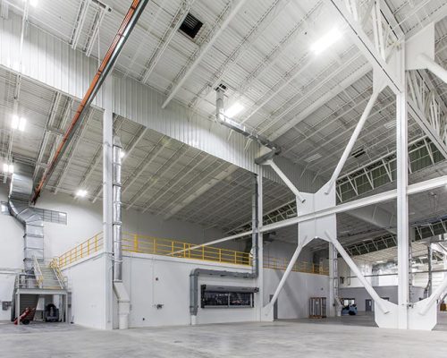 Interior of Lufthansa Technik Heavy Maintenance Facility. Large open space with white walls and bright lighting.