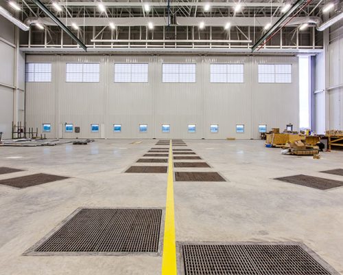 Interior of Lufthansa Technik Heavy Maintenance Facility. Large open space with white walls and bright lighting.