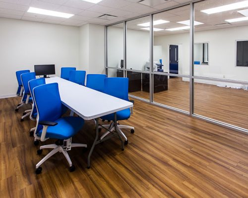 Conference room inside MAAS Aviation Painting Facility. Large room with conference table and blue chairs in the center.