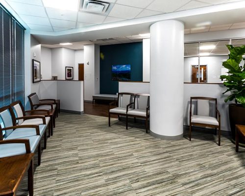 Interior rendering of waiting area. Chairs line the walls.