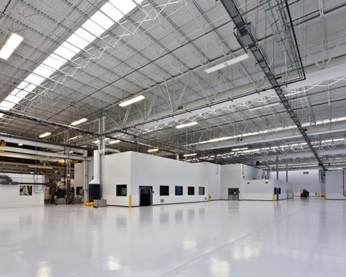 Interior of the Rolls Royce Crosspointe Rotatives Facility. Large, industrial, open space with fluorescent lighting.