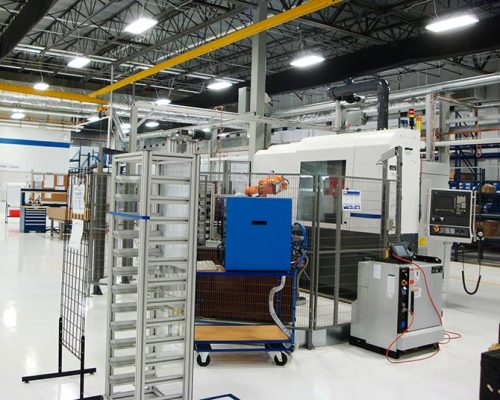 Interior of Turbomeca TMM Manufacturing Facility. Machinery in large industrial room with florescent lighting.