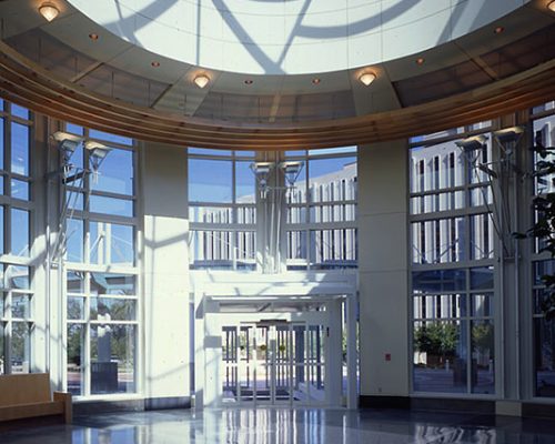 Interior photo of main entry. Glass dome and full height windows on the walls surround main doors.