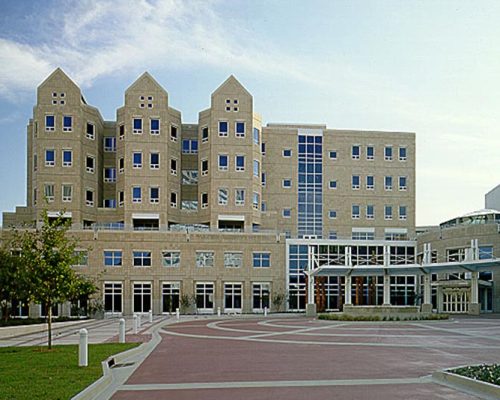 Exterior photo of Wolfson Children's Hospital during the day. Brick drive leads up to six-story tan bricked building.